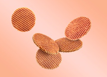 Image of Yummy Dutch waffles (stroopwafels) flying on pink beige gradient background