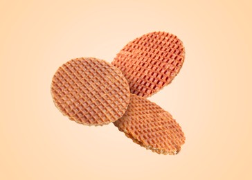 Image of Yummy Dutch waffles (stroopwafels) flying on beige background