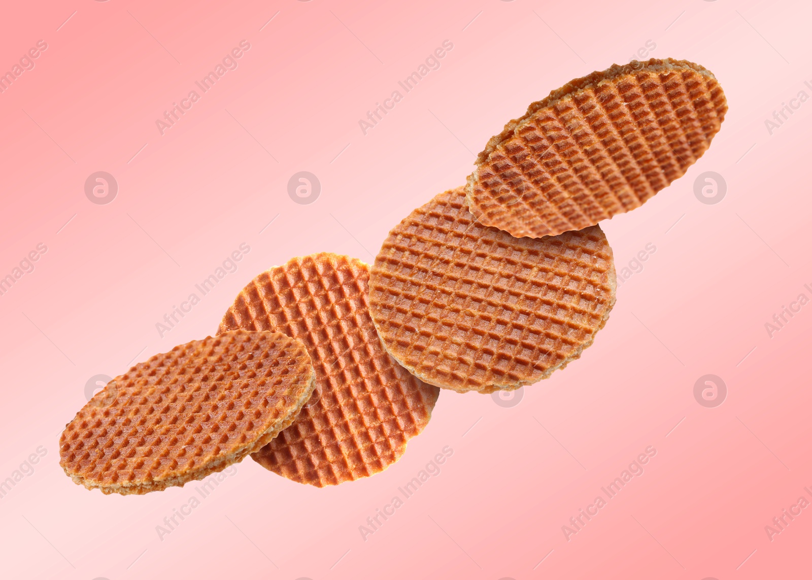 Image of Yummy Dutch waffles (stroopwafels) flying on pink gradient background