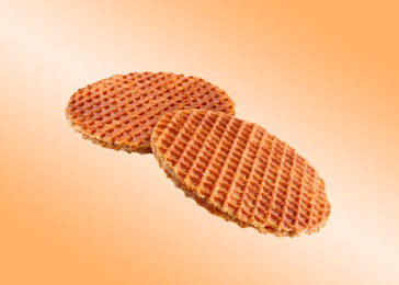 Image of Yummy Dutch waffles (stroopwafels) flying on orange gradient background