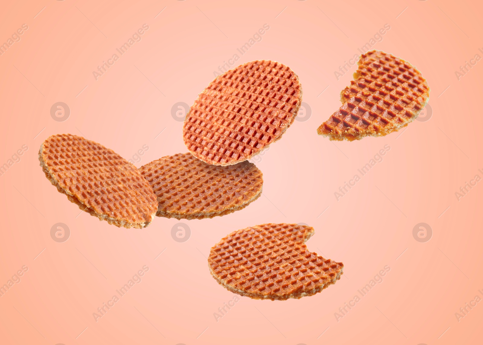 Image of Yummy Dutch waffles (stroopwafels) flying on pink beige background