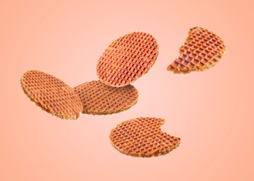 Image of Yummy Dutch waffles (stroopwafels) flying on pink beige background