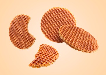 Image of Yummy Dutch waffles (stroopwafels) flying on beige background