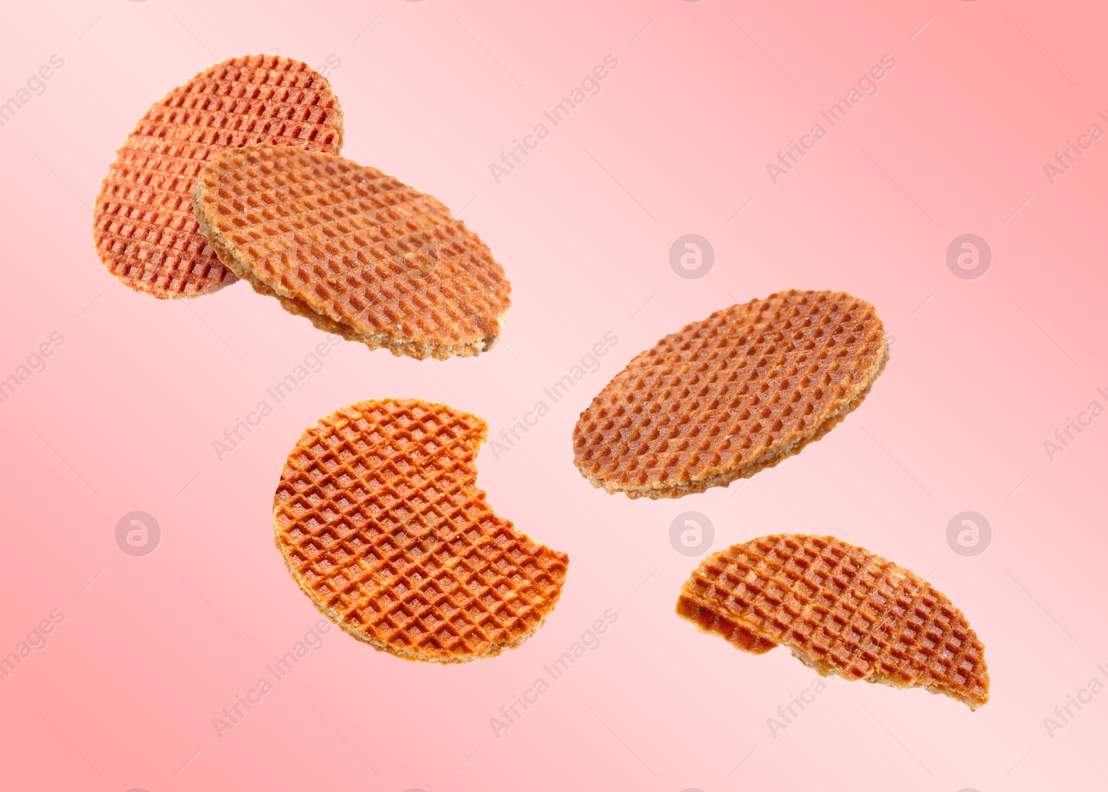 Image of Yummy Dutch waffles (stroopwafels) flying on pink gradient background