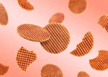 Image of Yummy Dutch waffles (stroopwafels) flying on pink beige gradient background