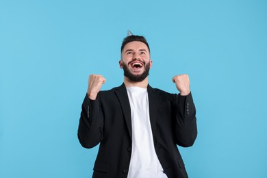 Photo of Happy Birthday. Handsome man with party hat on light blue background