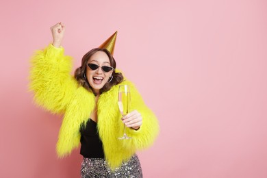 Photo of Birthday celebration. Woman with glass of sparkling wine on pink background. Space for text