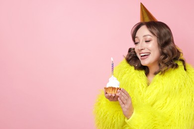 Photo of Birthday celebration. Woman with cupcake on pink background. Space for text