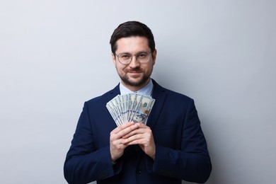 Photo of Greedy banker with dollar banknotes on grey background