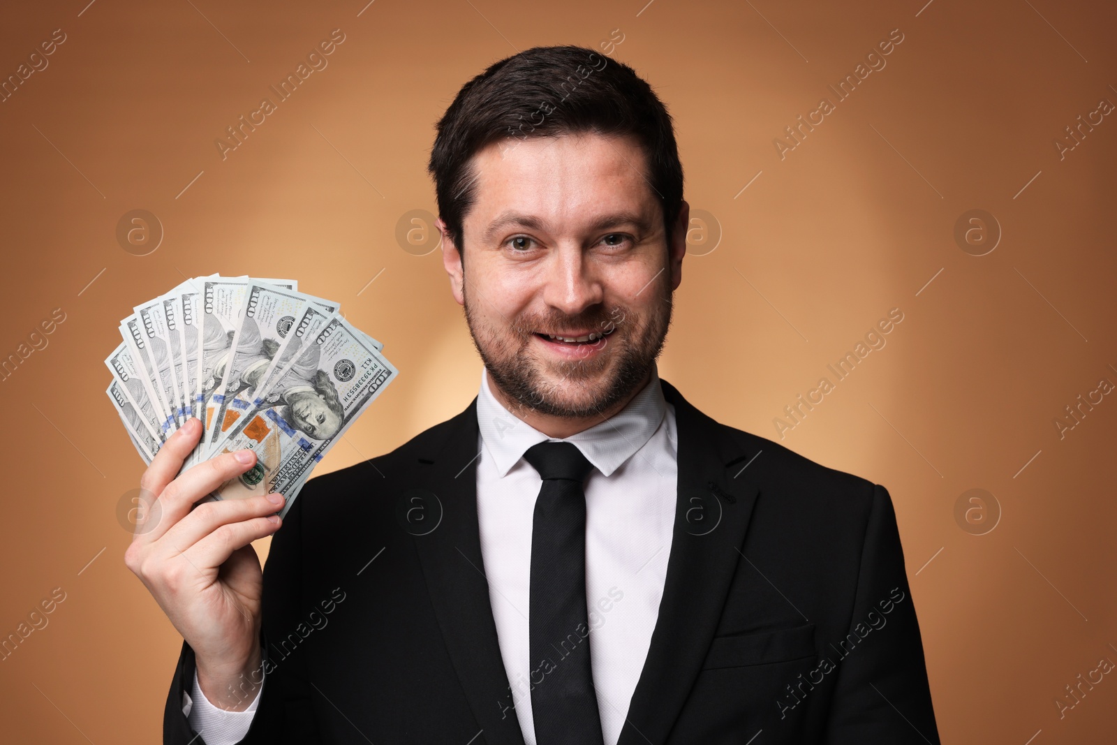 Happy greedy banker with dollar banknotes on golden background Photo of Happy greedy banker with dollar banknotes on golden background