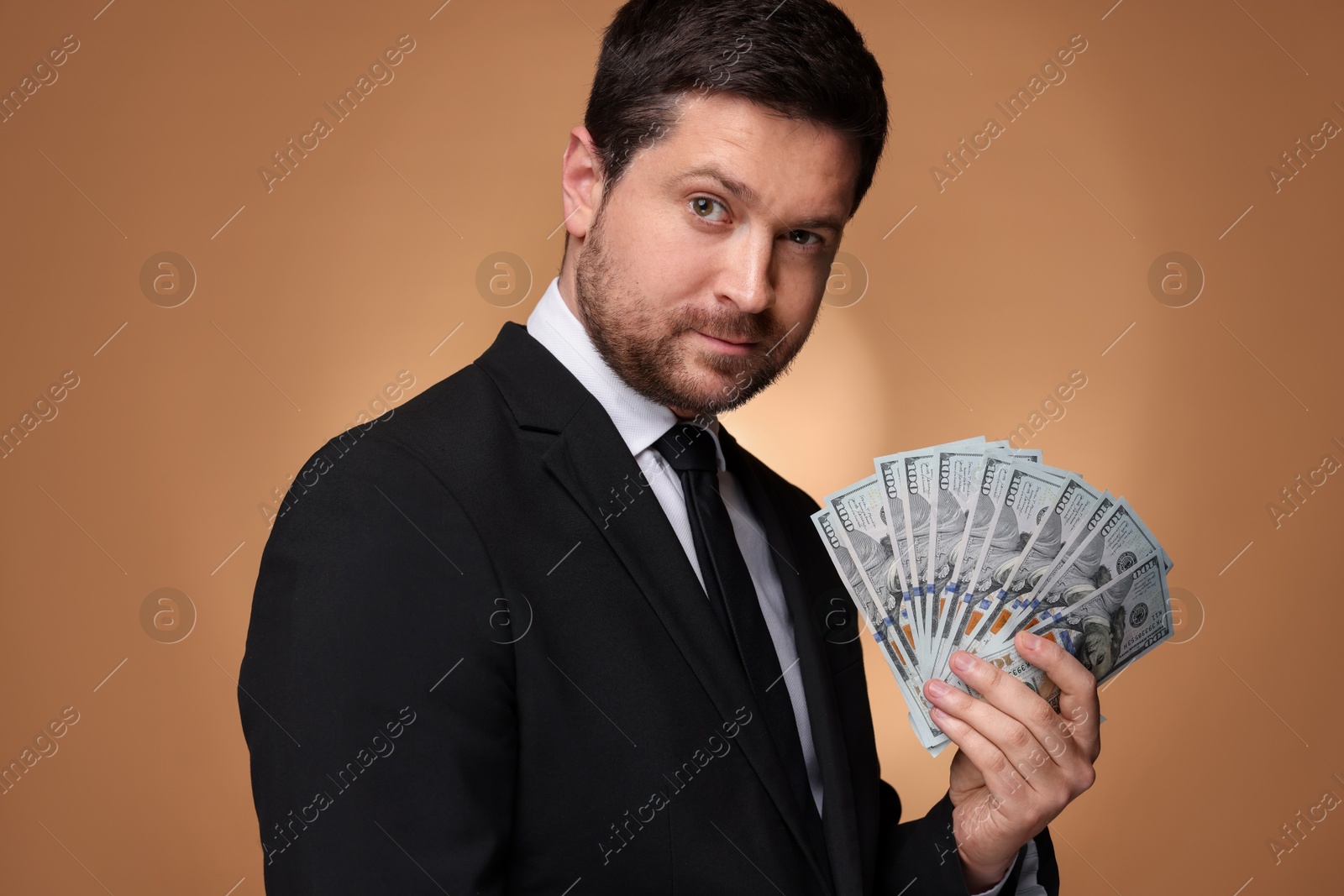 Greedy banker with dollar banknotes on golden background Photo of Greedy banker with dollar banknotes on golden background