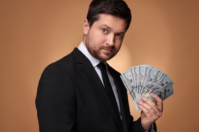 Photo of Greedy banker with dollar banknotes on golden background