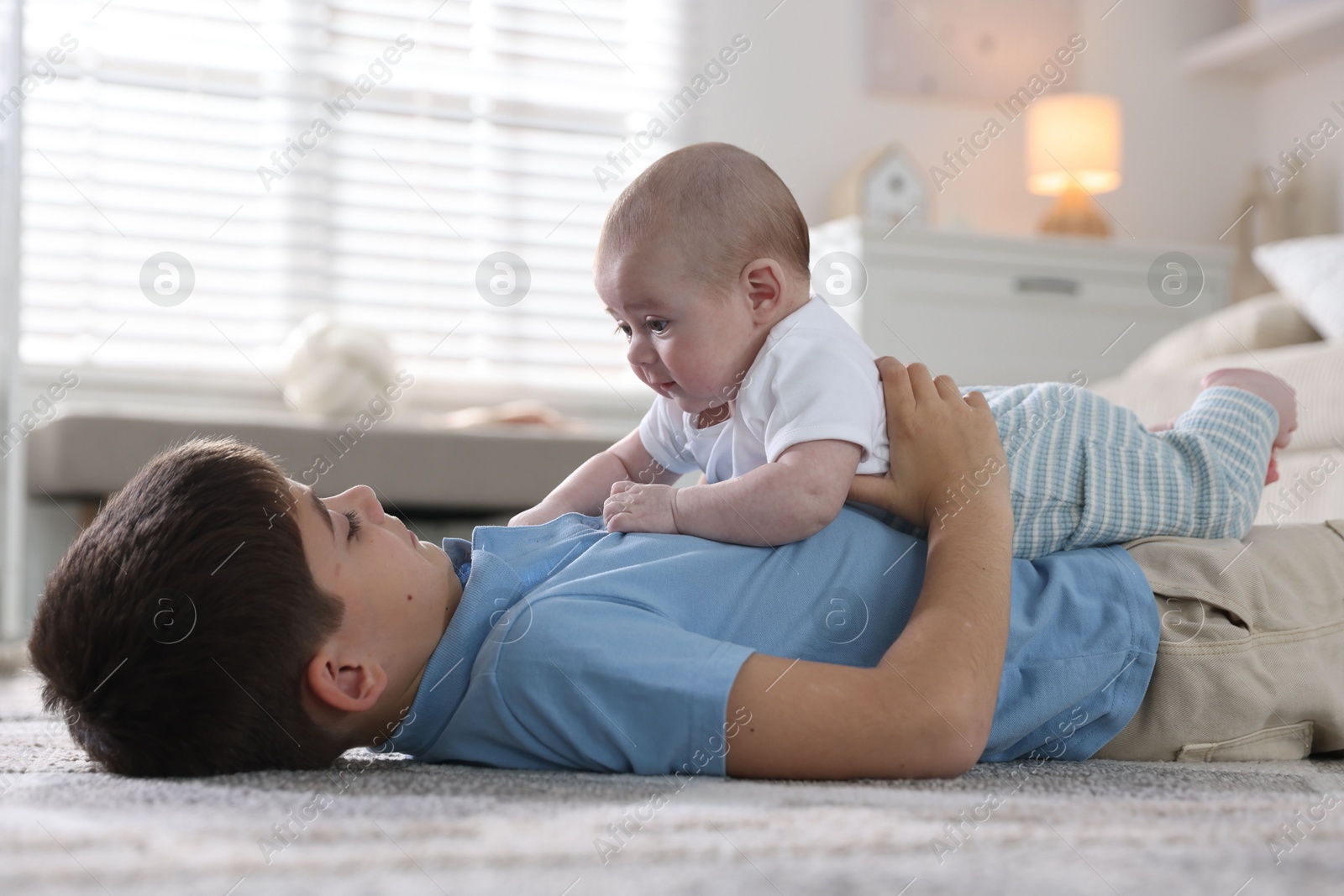Cute little brothers on floor at home Photo of Cute little brothers on floor at home