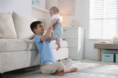 Photo of Cute little brothers playing on floor at home