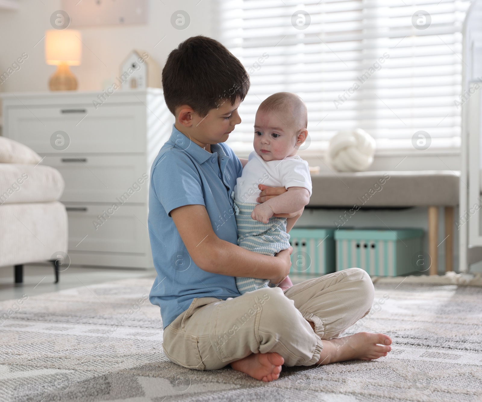 Cute little brothers hugging on floor at home Photo of Cute little brothers hugging on floor at home