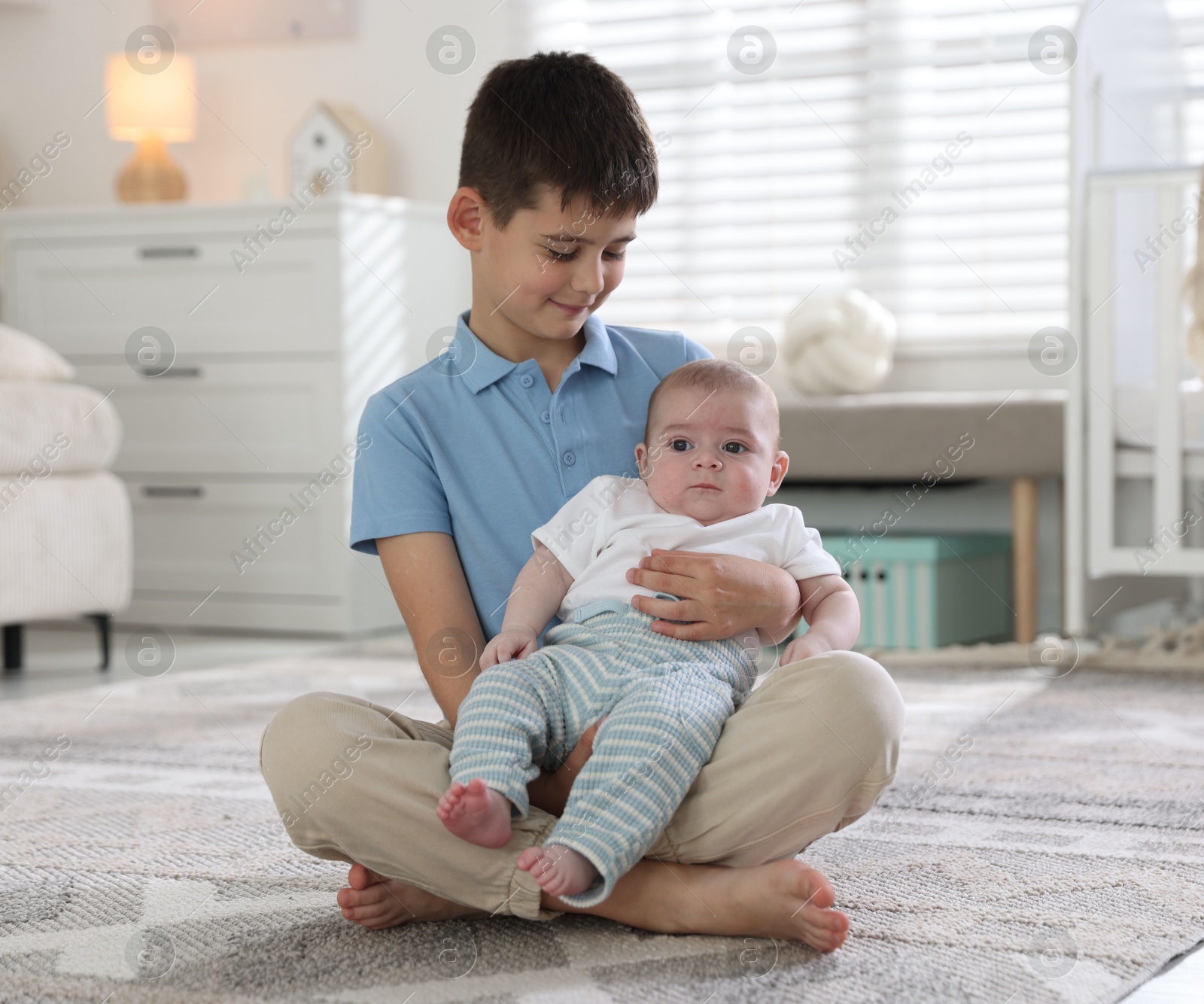 Cute little brothers sitting on floor at home Photo of Cute little brothers sitting on floor at home