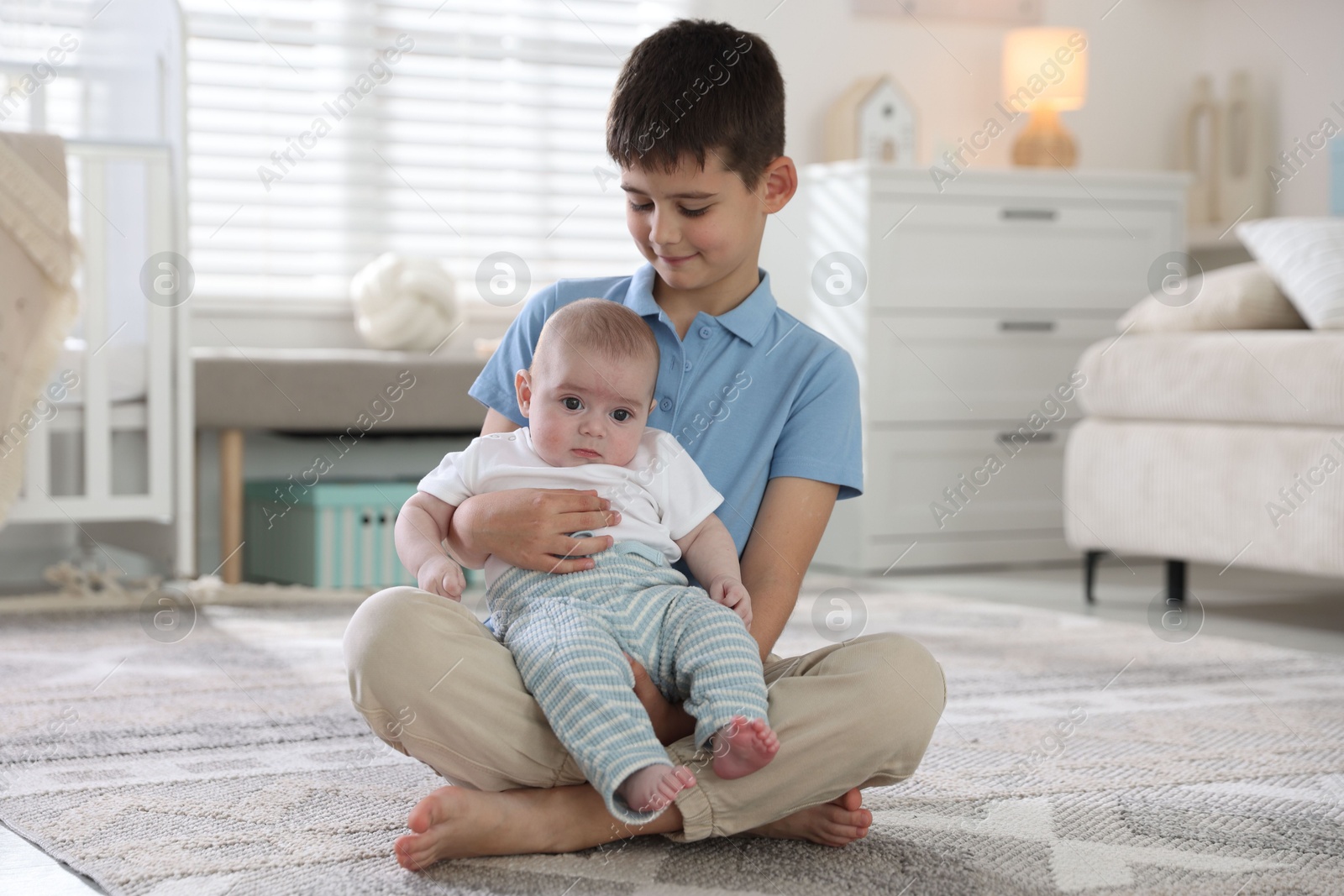 Cute little brothers sitting on floor at home Photo of Cute little brothers sitting on floor at home