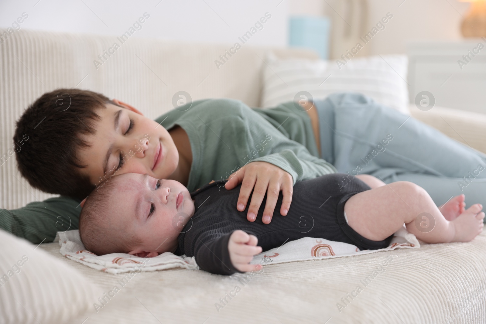 Cute little brothers on sofa at home Photo of Cute little brothers on sofa at home
