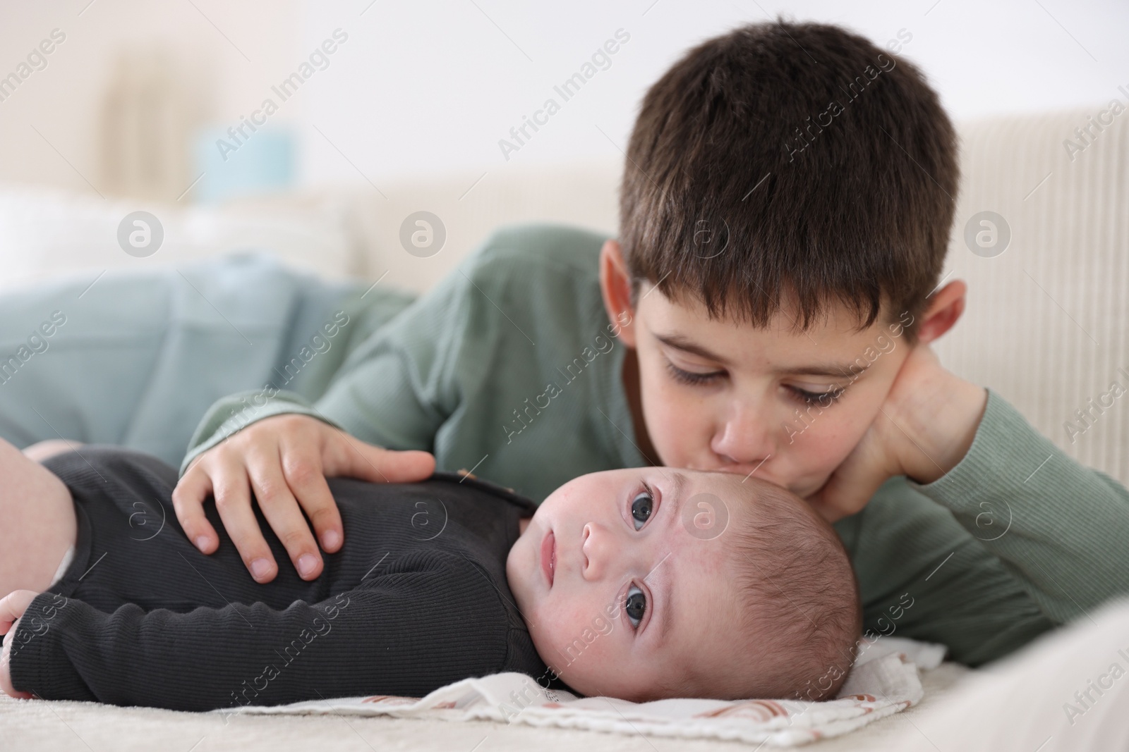 Cute little brothers on sofa at home Photo of Cute little brothers on sofa at home