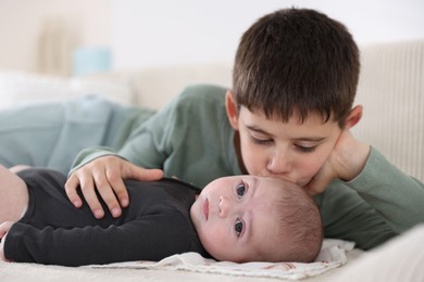 Photo of Cute little brothers on sofa at home