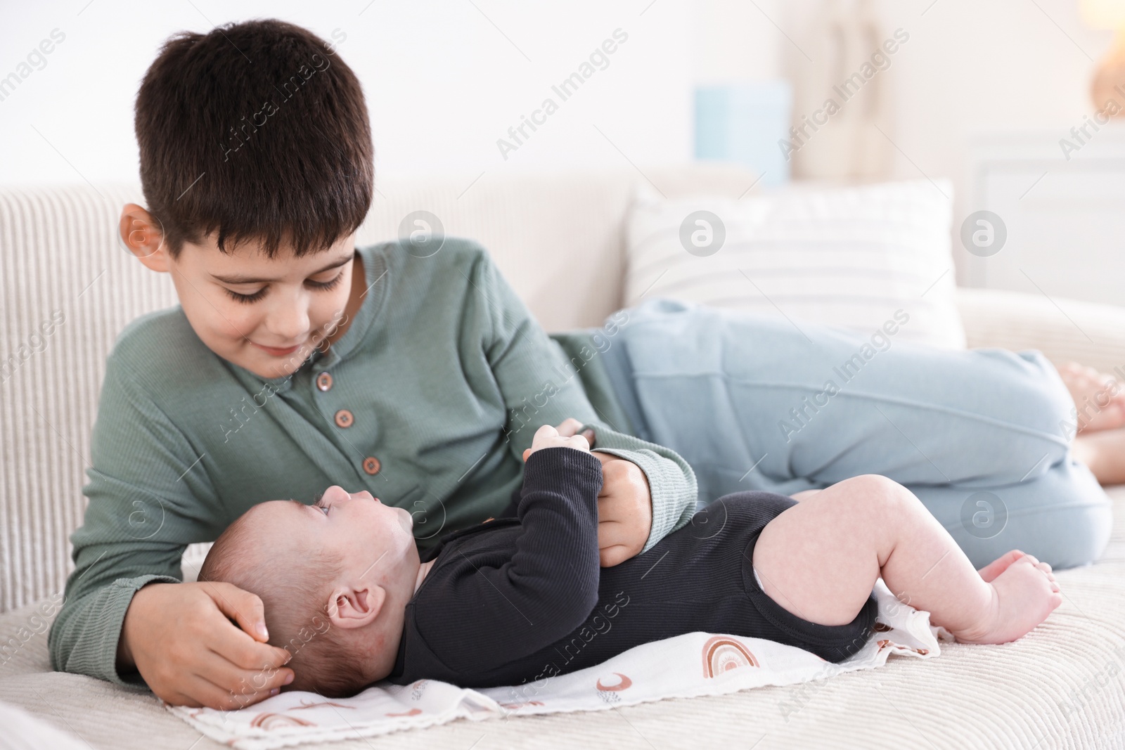 Cute little brothers on sofa at home Photo of Cute little brothers on sofa at home