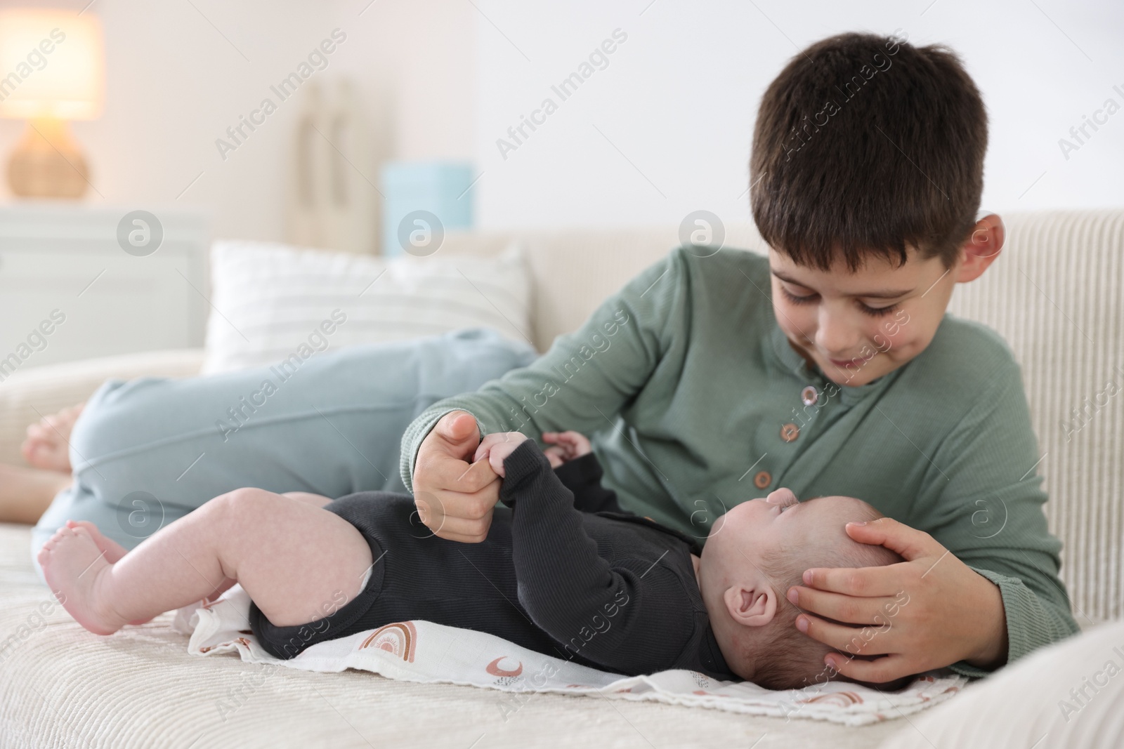 Cute little brothers on sofa at home Photo of Cute little brothers on sofa at home