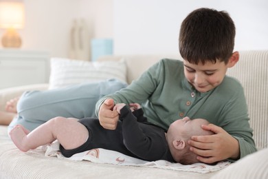 Photo of Cute little brothers on sofa at home