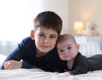Photo of Family portrait of cute little brothers on bed at home