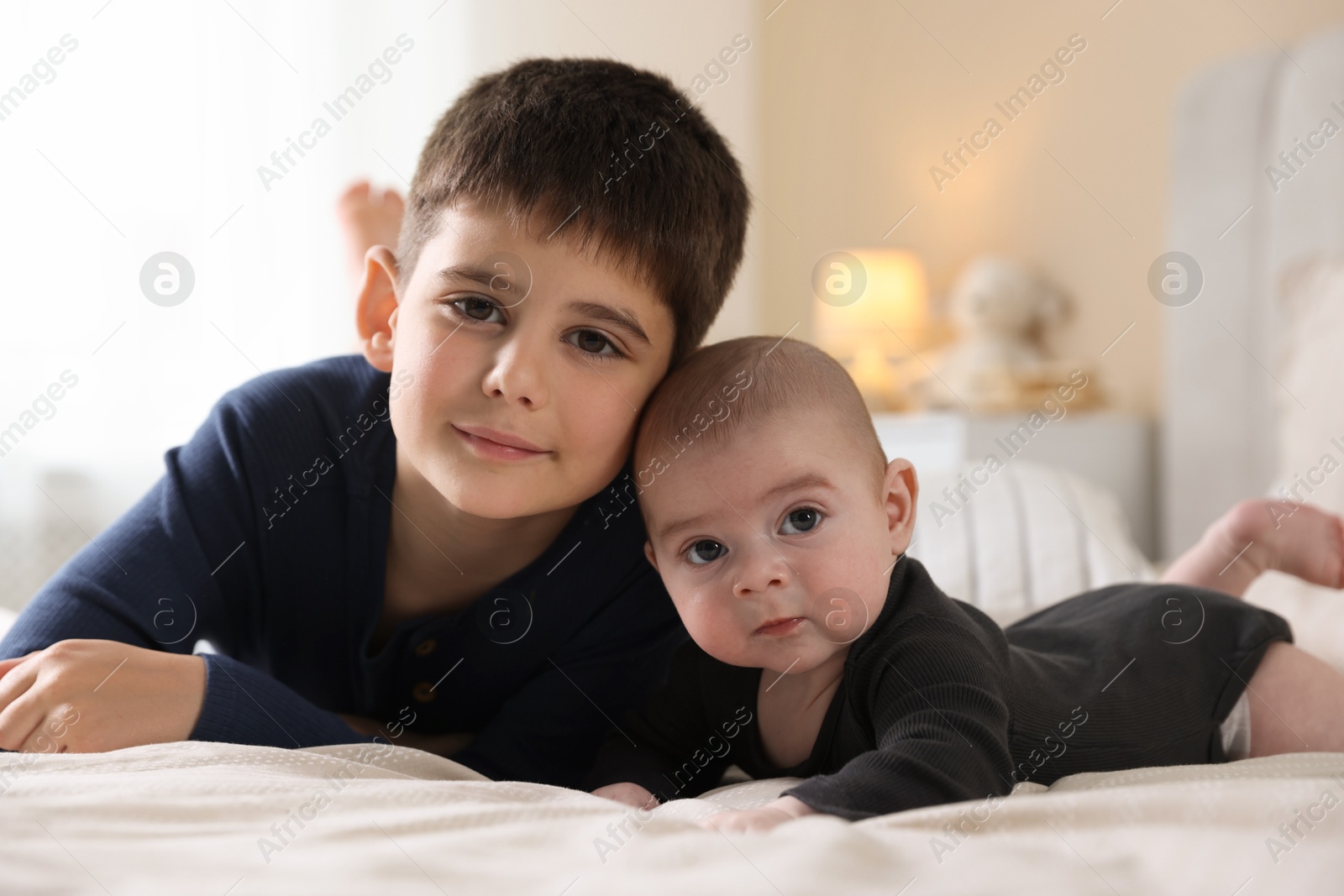 Family portrait of cute little brothers on bed at home Photo of Family portrait of cute little brothers on bed at home