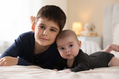 Photo of Family portrait of cute little brothers on bed at home