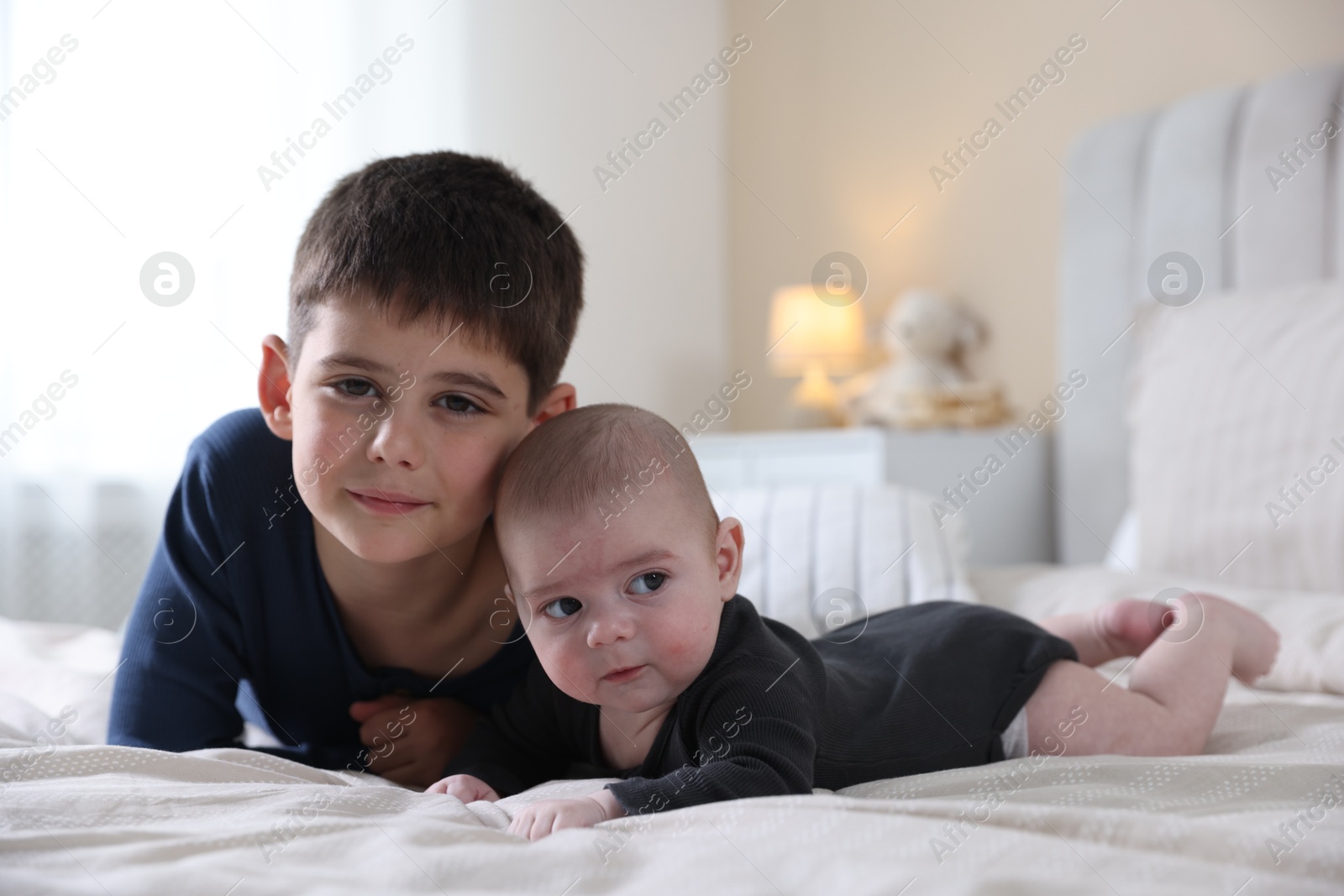 Cute little brothers on bed at home Photo of Cute little brothers on bed at home