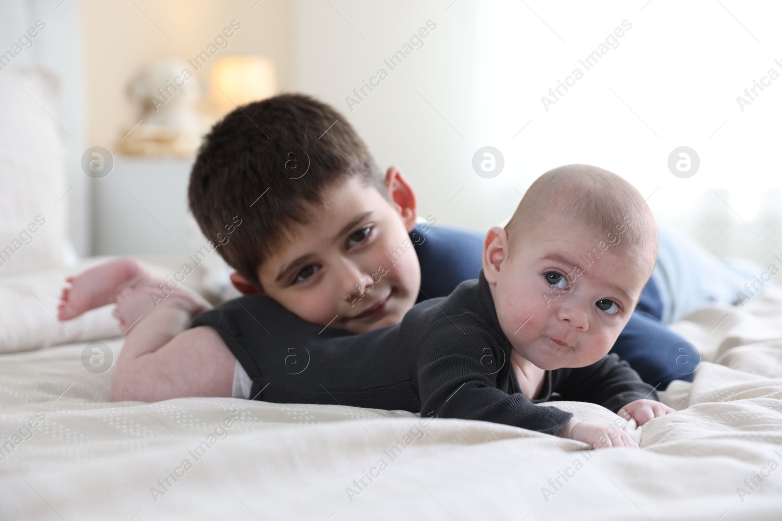 Cute little brothers on bed at home Photo of Cute little brothers on bed at home