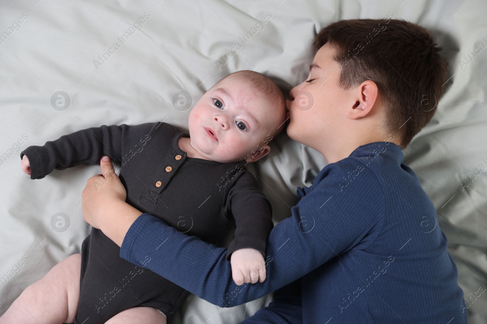Cute little brothers on bed, above view Photo of Cute little brothers on bed, above view