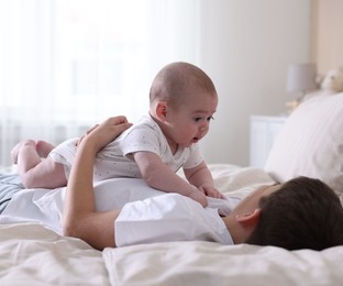Photo of Cute little brothers on bed at home