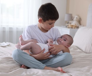 Photo of Cute little brothers on bed at home