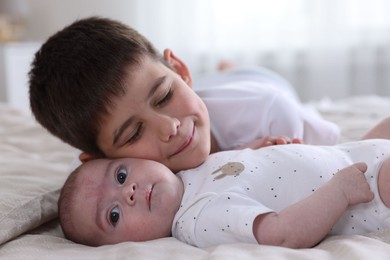 Photo of Cute little brothers on bed at home, closeup
