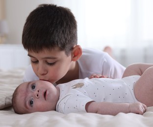 Photo of Cute little brothers on bed at home