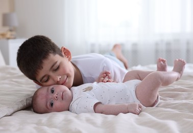 Photo of Cute little brothers on bed at home