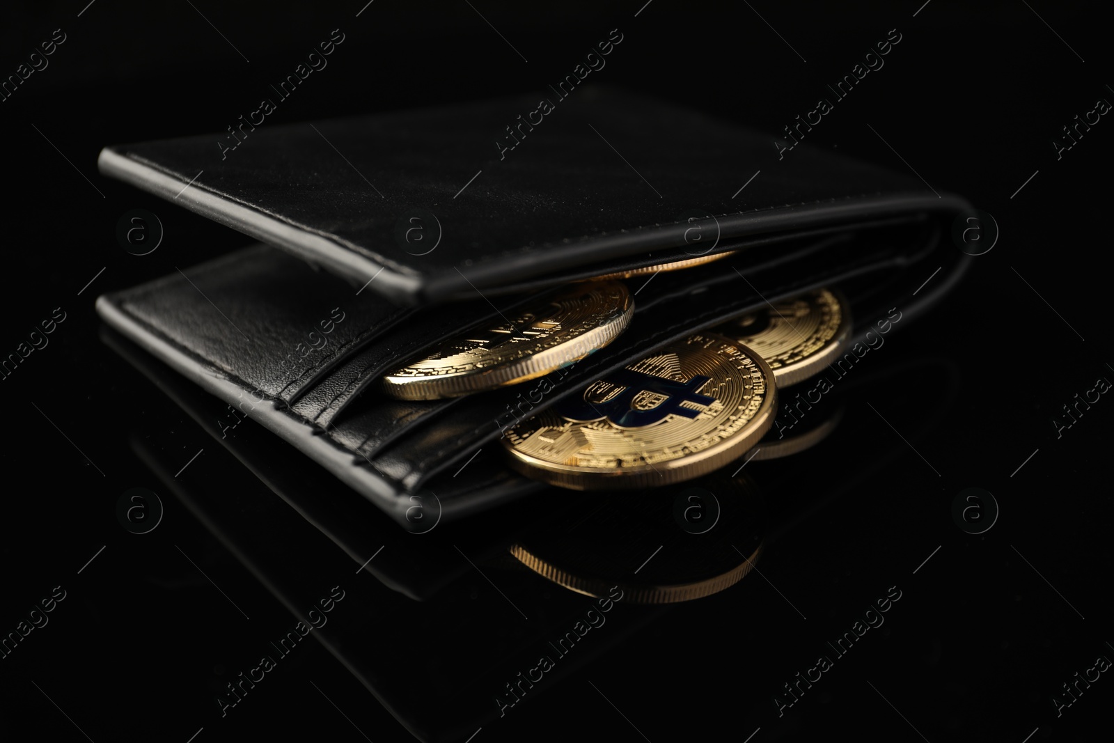 Cryptocurrency. Bitcoins in wallet on black mirror surface, closeup Photo of Cryptocurrency. Bitcoins in wallet on black mirror surface, closeup