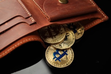 Photo of Cryptocurrency. Bitcoins in wallet on black mirror surface, closeup