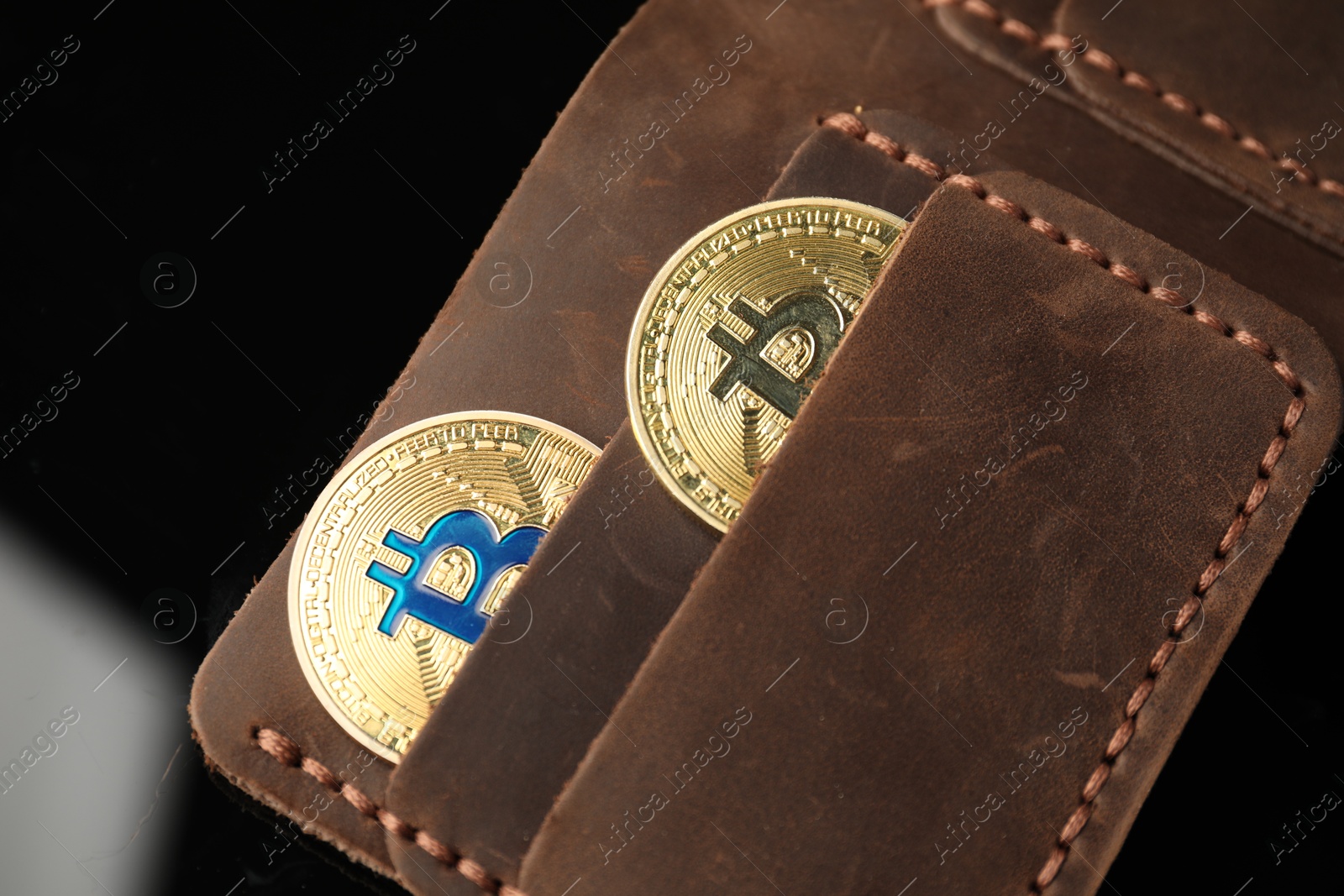 Cryptocurrency. Bitcoins in wallet on black mirror surface, above view Photo of Cryptocurrency. Bitcoins in wallet on black mirror surface, above view