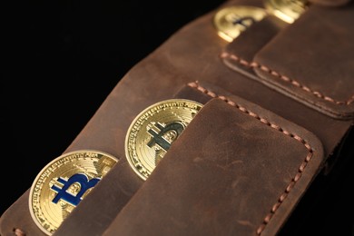 Photo of Cryptocurrency. Bitcoins in wallet on black mirror surface, closeup