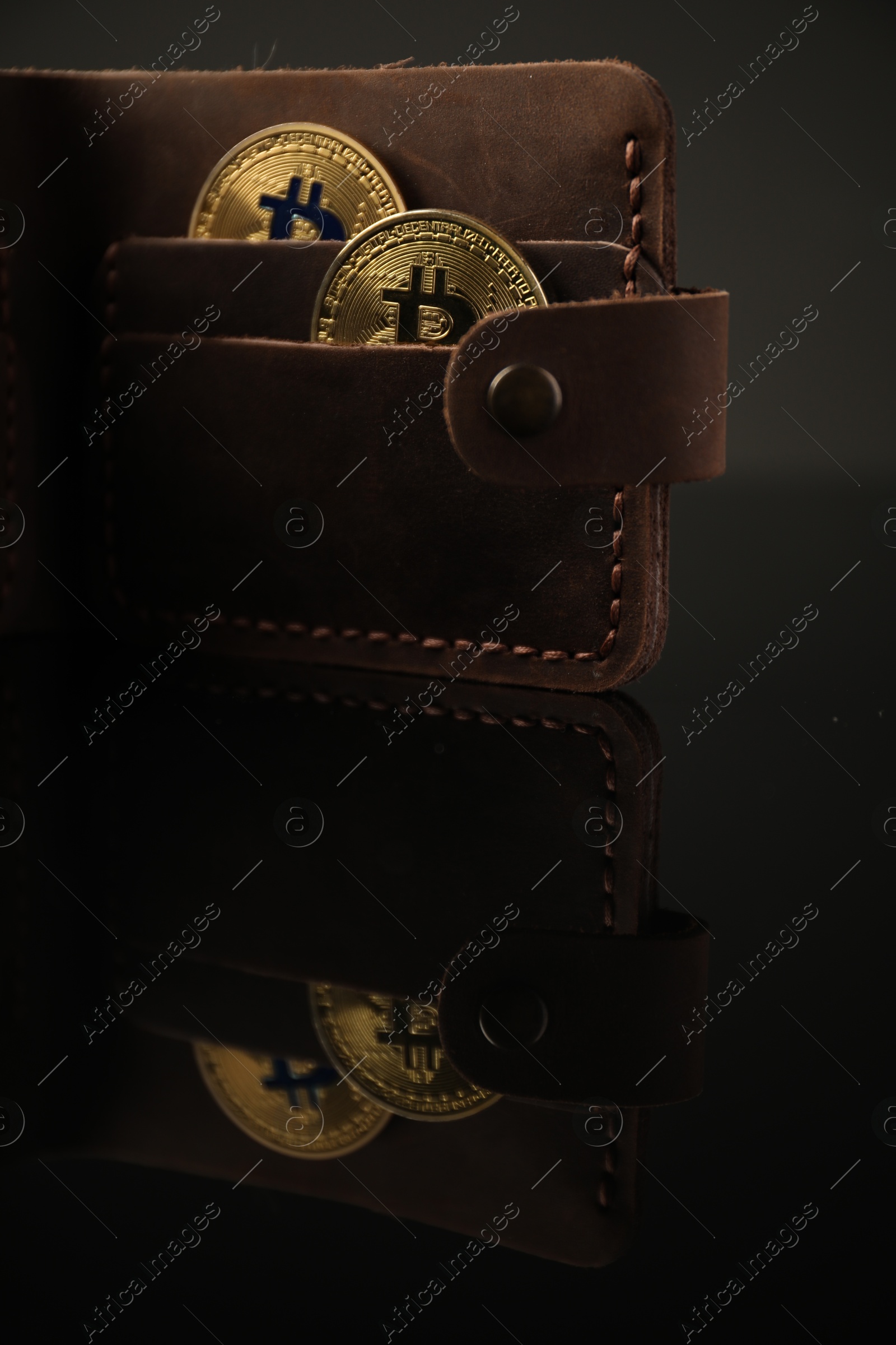 Cryptocurrency. Bitcoins in wallet on black mirror surface, closeup Photo of Cryptocurrency. Bitcoins in wallet on black mirror surface, closeup