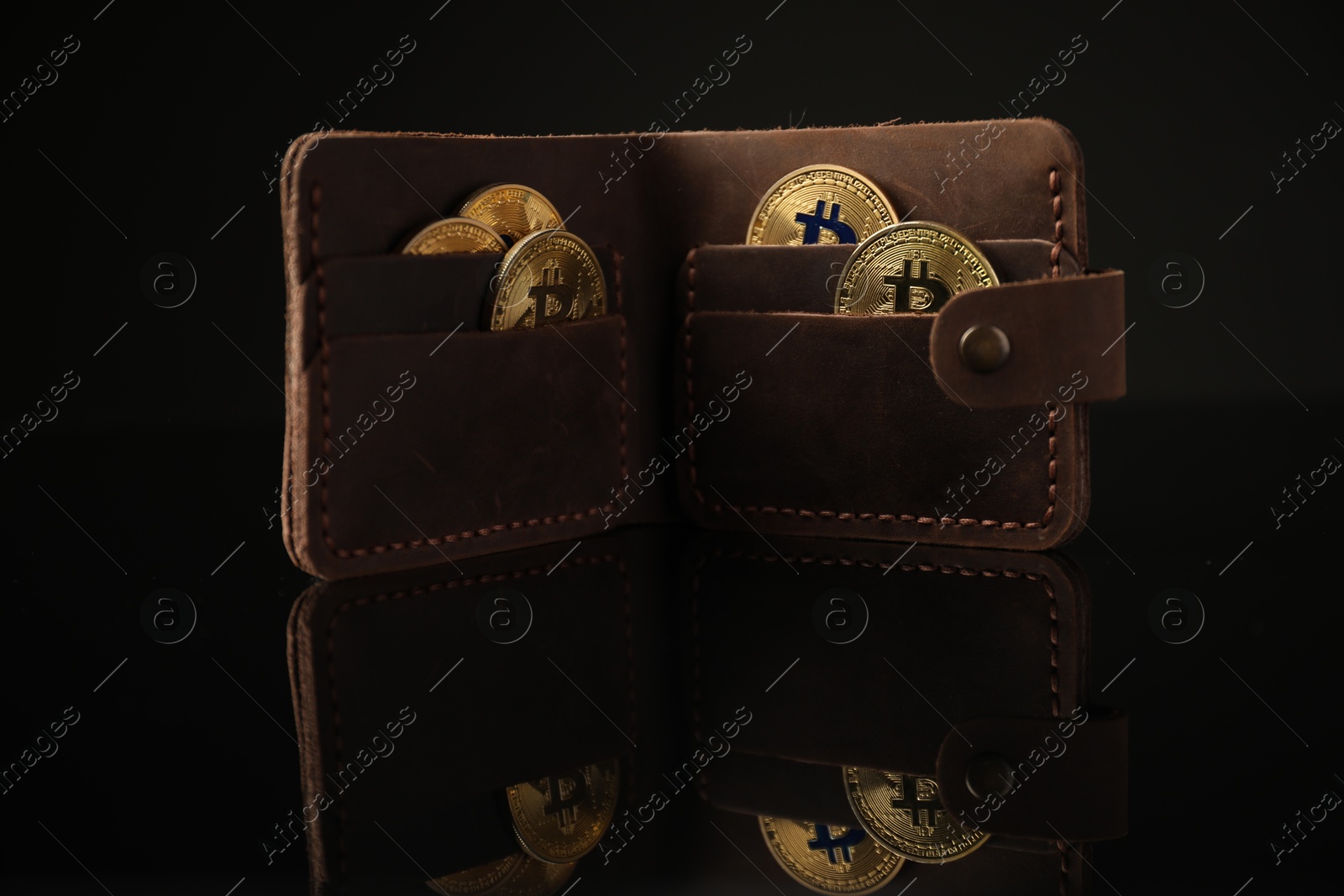 Cryptocurrency. Bitcoins in wallet on black mirror surface Photo of Cryptocurrency. Bitcoins in wallet on black mirror surface