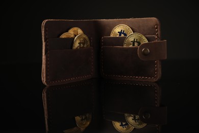 Photo of Cryptocurrency. Bitcoins in wallet on black mirror surface