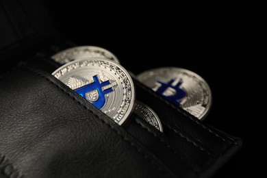 Photo of Cryptocurrency. Bitcoins in wallet on dark background, closeup