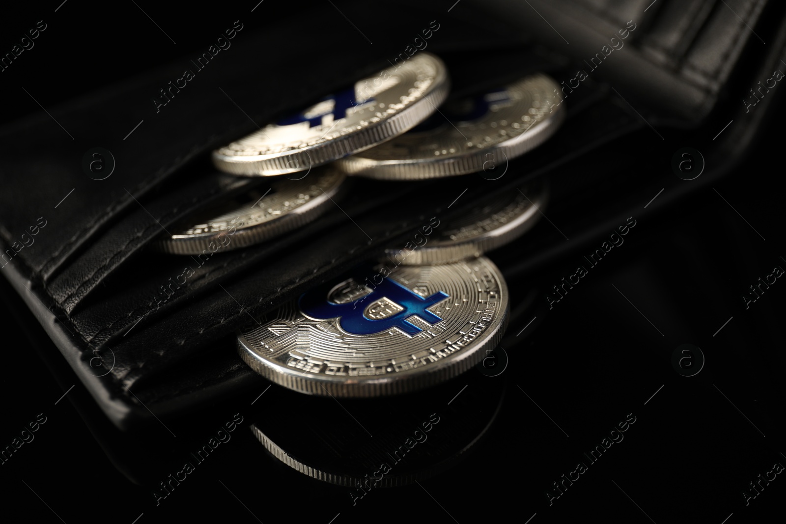 Cryptocurrency. Bitcoins in wallet on black mirror surface, closeup Photo of Cryptocurrency. Bitcoins in wallet on black mirror surface, closeup