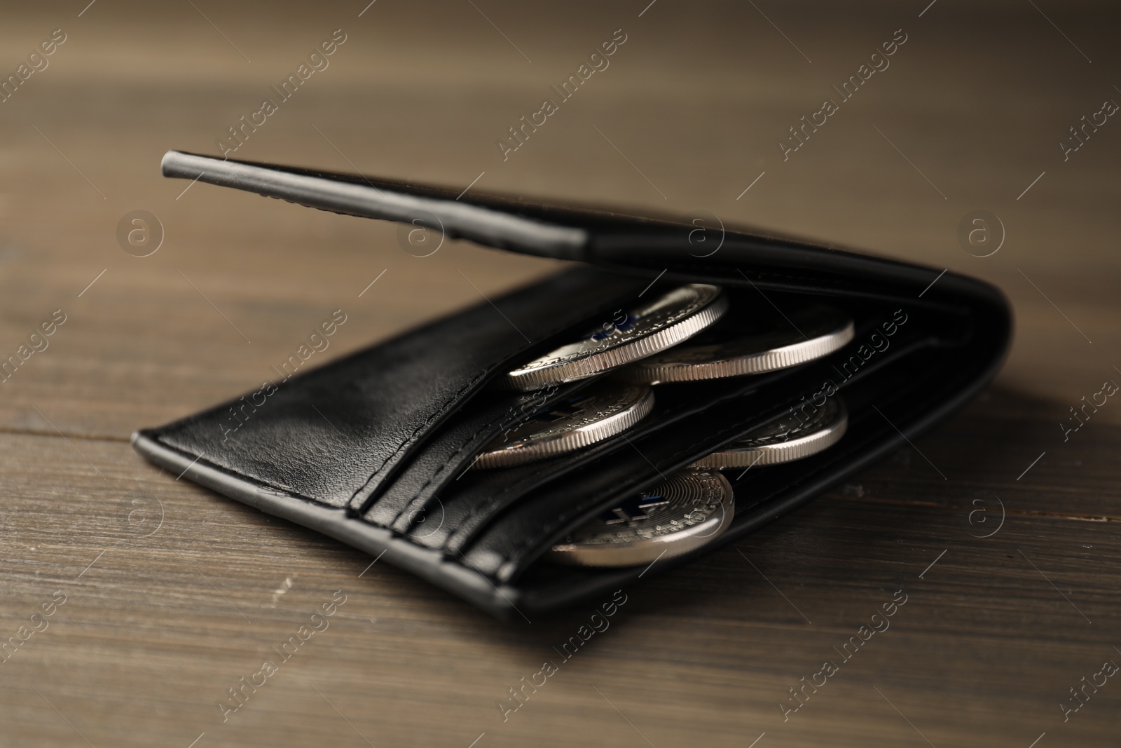 Cryptocurrency. Bitcoins in wallet on wooden background, closeup Photo of Cryptocurrency. Bitcoins in wallet on wooden background, closeup