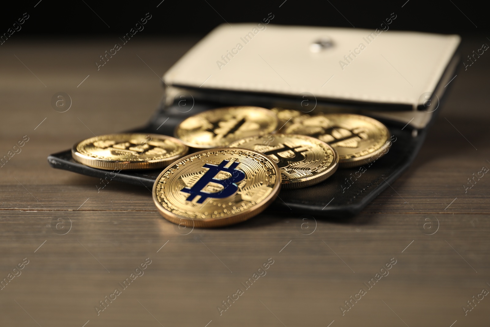 Cryptocurrency. Bitcoins and wallet on wooden background, closeup Photo of Cryptocurrency. Bitcoins and wallet on wooden background, closeup