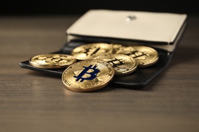 Photo of Cryptocurrency. Bitcoins and wallet on wooden background, closeup